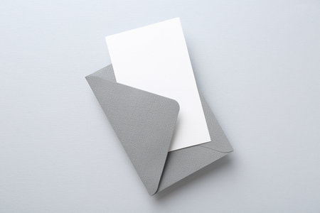 Blank invitation card and envelope on light gray background, top viewの写真素材