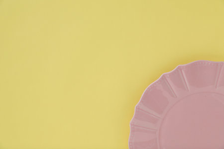 One empty plate on yellow background, top view. Space for textの写真素材