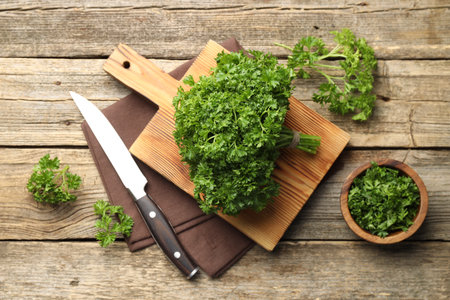Fresh parsley and knife on wooden table, flat layの写真素材