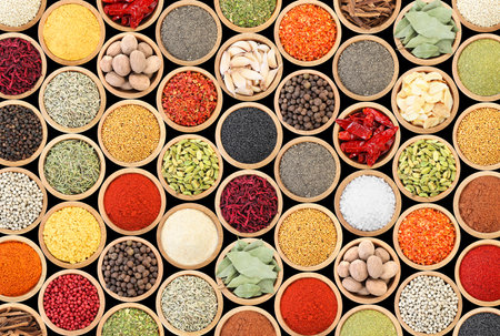 Set of different aromatic spices in bowls on black background, flat layの写真素材