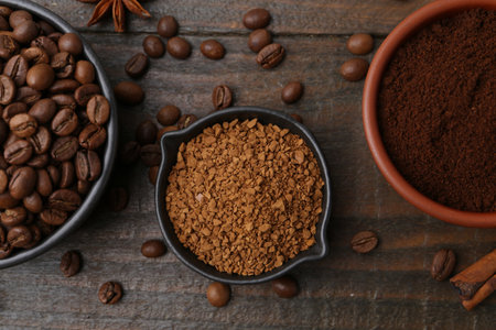 Different types of instant coffee, beans and spices on wooden table, flat layの写真素材