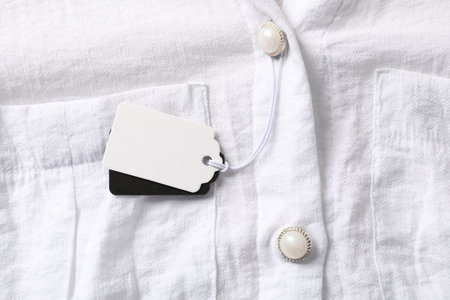Cardboard tags on white shirt, top viewの写真素材