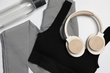 Sportswear, bottle of water and headphones on white background, flat layの写真素材