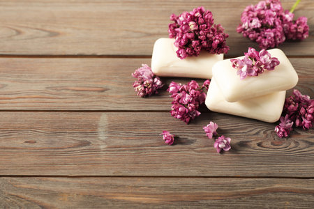 Soap bars and lilac flowers on wooden table. Space for textの写真素材