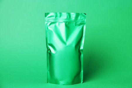 One zipper stand-up pouch on green background. Mockup for designの写真素材