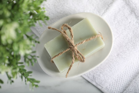 Soap bar, towel and floral decor on white marble table, top viewの写真素材