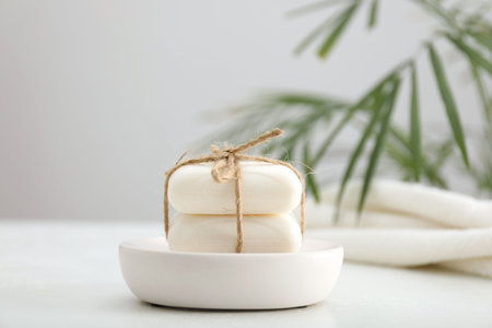 Soap bars on white table against gray background, closeup