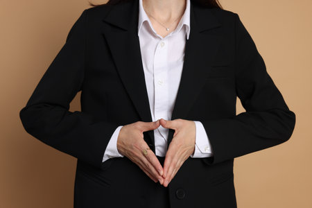 Woman in suit on beige background, closeupの写真素材