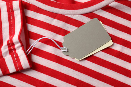 Cardboard tags on striped garment, top viewの写真素材