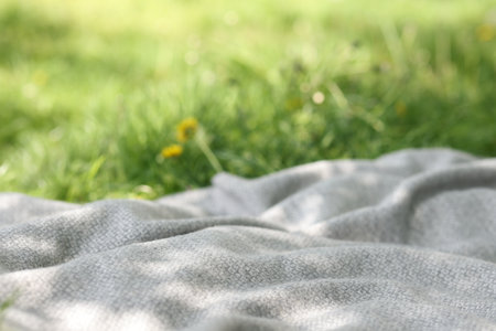 Light grey blanket for picnic on green grass outdoors, closeupの写真素材