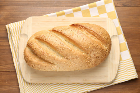 One bread loaf on wooden table, top view