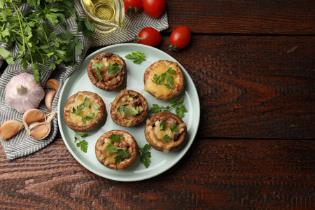 Tasty stuffed mushrooms and ingredients on wooden table, flat lay. Space for textの写真素材