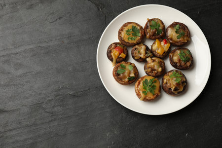 Tasty stuffed mushrooms on black table, top view. Space for textの写真素材