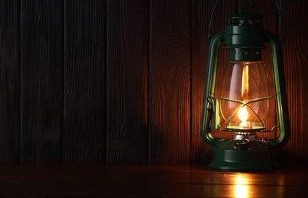 Vintage kerosene lamp on wooden table. Space for textの写真素材