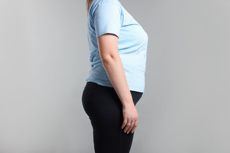 Weight loss. Plus size woman on gray background, closeupの写真素材