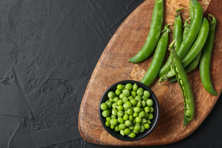 Fresh ripe green peas on black table, top view. Space for textの写真素材
