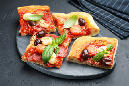 Pieces of tasty homemade pizza on black table, closeupの写真素材