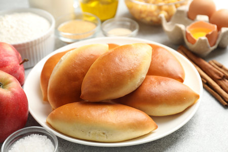 Tasty baked patties and ingredients on light grey table, closeupの写真素材