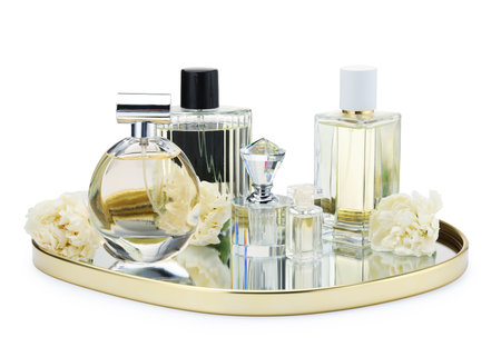 Many different perfume bottles and flowers isolated on whiteの写真素材