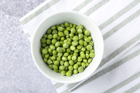 Fresh ripe green peas on grey table, top viewの写真素材