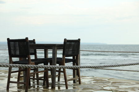Chairs and table on beach near seaの写真素材
