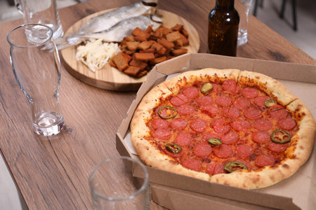 Empty beer glasses and snacks on wooden table indoors, closeupの写真素材