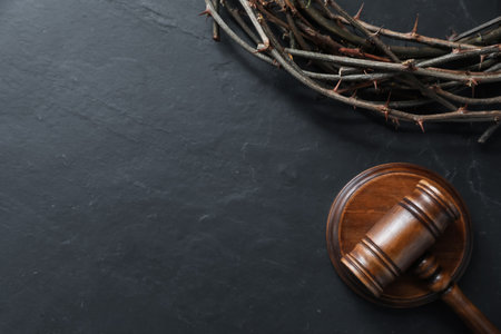Judge's gavel and crown of thorns on black table, flat lay. Space for textの写真素材