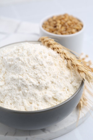 Wheat flour, grain and spikes on white table, closeupの写真素材