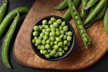 Fresh ripe green peas on black table, flat layの写真素材