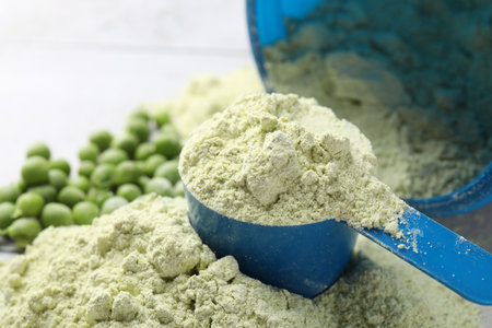 Protein powder and green peas on light tiled table, closeupの写真素材
