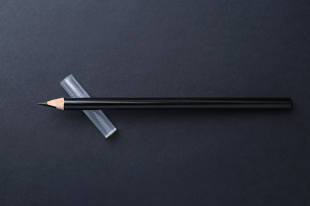 Black eyebrow pencil on dark background, top viewの写真素材