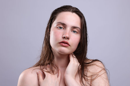 Portrait of woman with natural skin complexion on gray background, closeupの写真素材