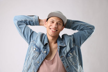 Young man in stylish baseball hat on light grey background