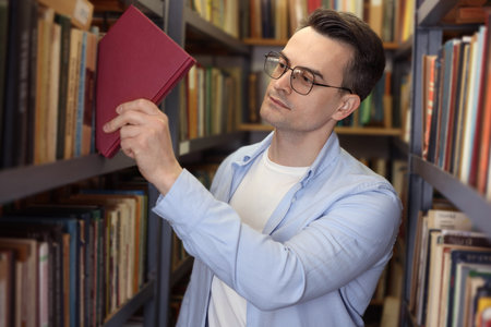 Man taking book from shelf in public library