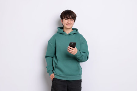 Teenage boy with smartphone on white background