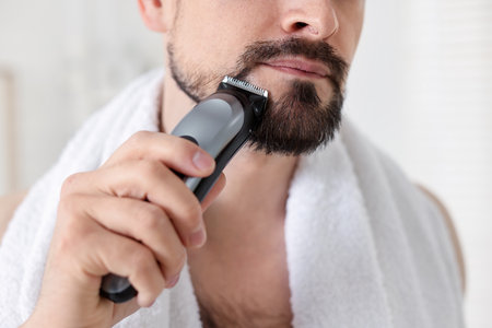 Man shaving with trimmer at home, closeupの写真素材