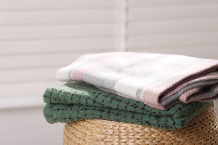 Wool scarves on wicker box indoors, closeup