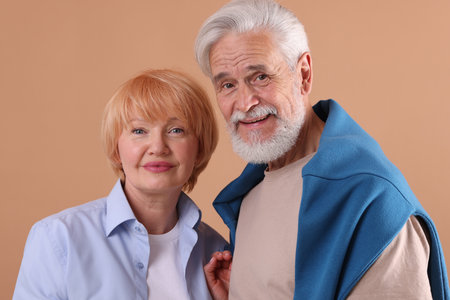 Lovely senior couple together on light brown backgroundの写真素材