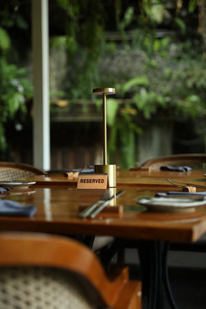 Sign with word Reserved on wooden table in restaurantの写真素材
