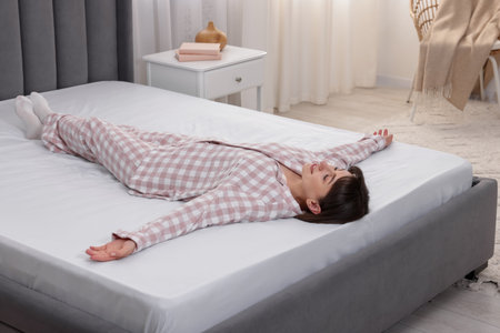Beautiful woman lying on soft mattress at home