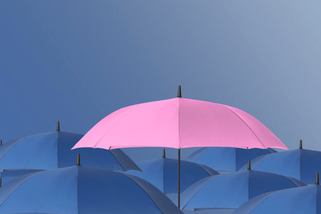 Pink umbrella among blue ones against color backgroundの写真素材