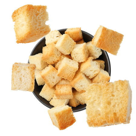 Delicious crispy croutons falling into bowl on white background, top viewの写真素材