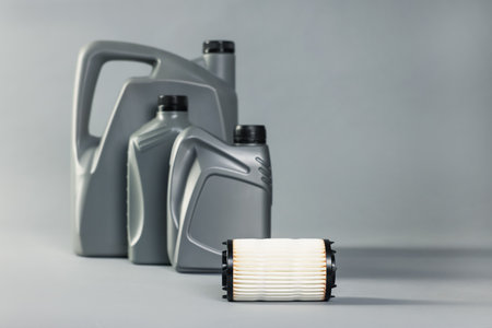 Motor oil in plastic canisters and filter on grey background, selective focusの写真素材