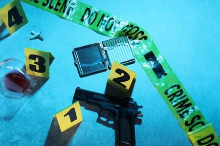 Forensic expertise. Crime scene with evidence, markers and police tape on blue background. Color toned effectの写真素材