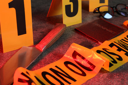Forensic expert. Yellow crime scene tape, markers, knife, passport and glasses on grey table, closeupの写真素材