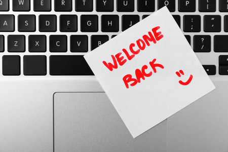 Paper note with words Welcome Back on laptop, top viewの写真素材