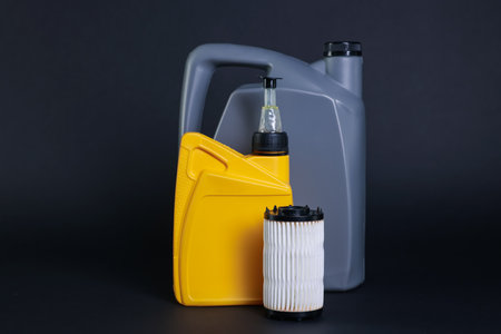 Motor oil in plastic canisters and filter on dark grey backgroundの写真素材