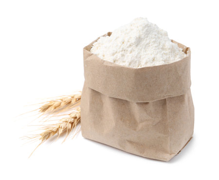 Wheat flour in paper bag and spikes on white backgroundの写真素材