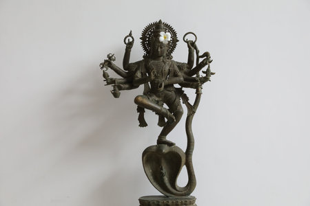 Bali, Indonesia - June 7, 2025: Beautiful Krishna statue with flower near white wall