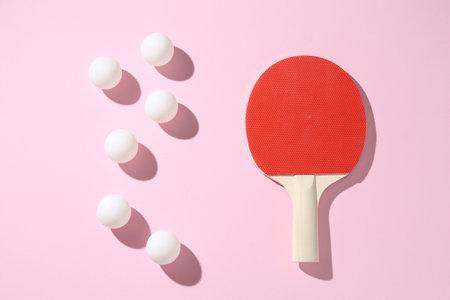 Ping pong racket and balls on pink background, flat lay
